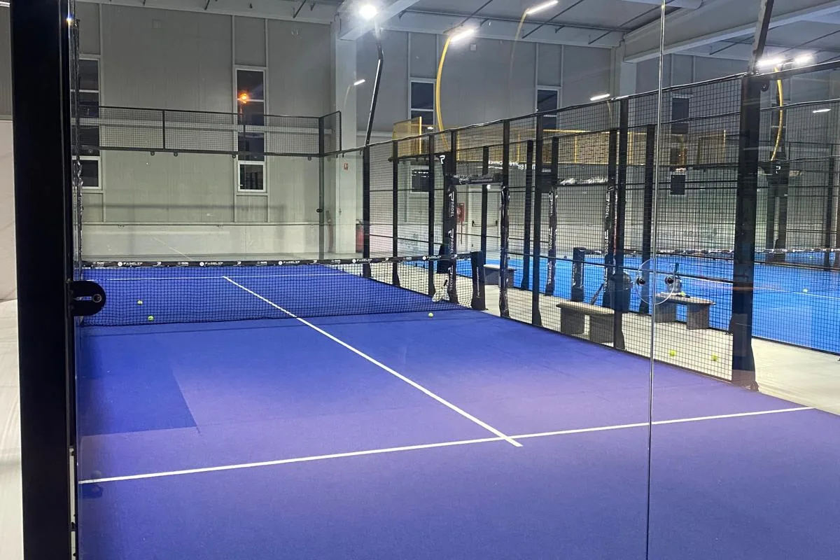 Teren de padel văzut prin peretele de sticlă securizată
