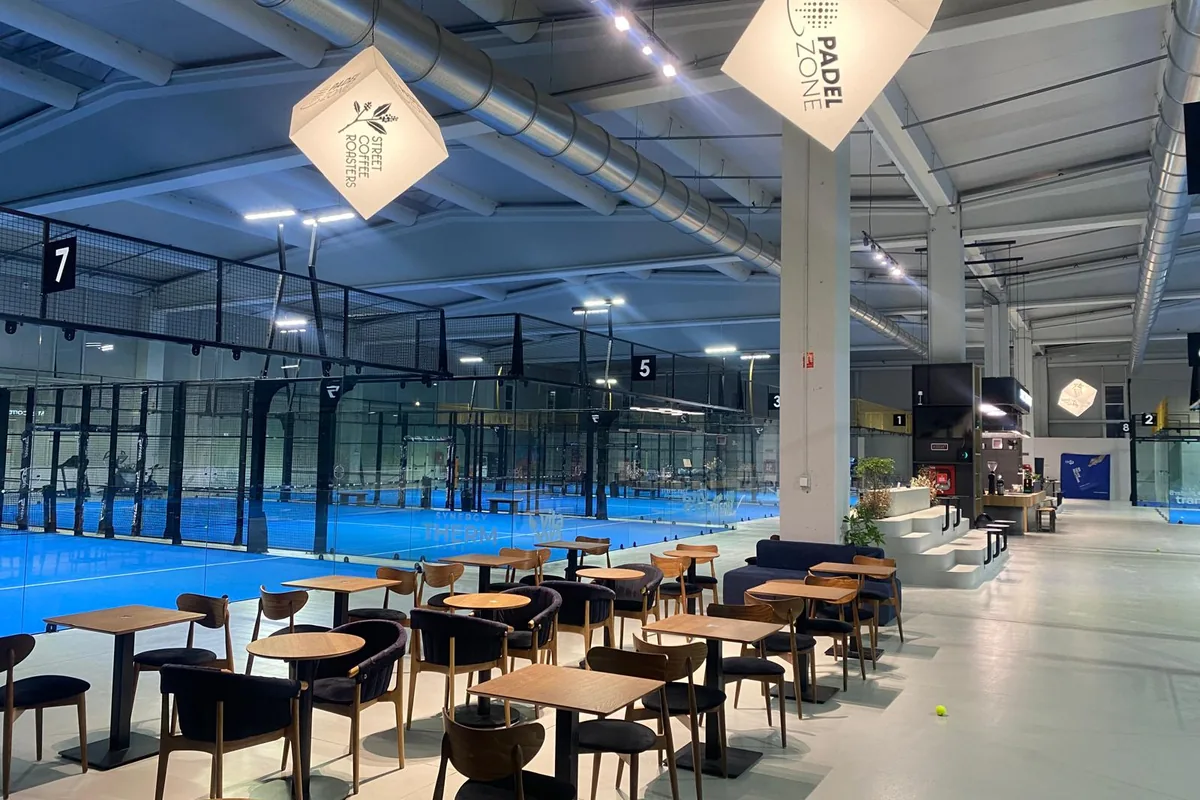 Zonă cu mese și scaune, lângă terenurile de padel